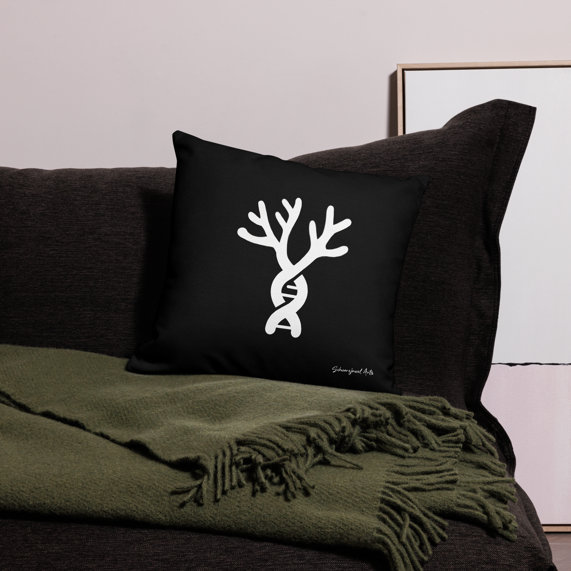 Schwarzes Kissen mit Coral DNA auf brauner Couch mit grüner Decke