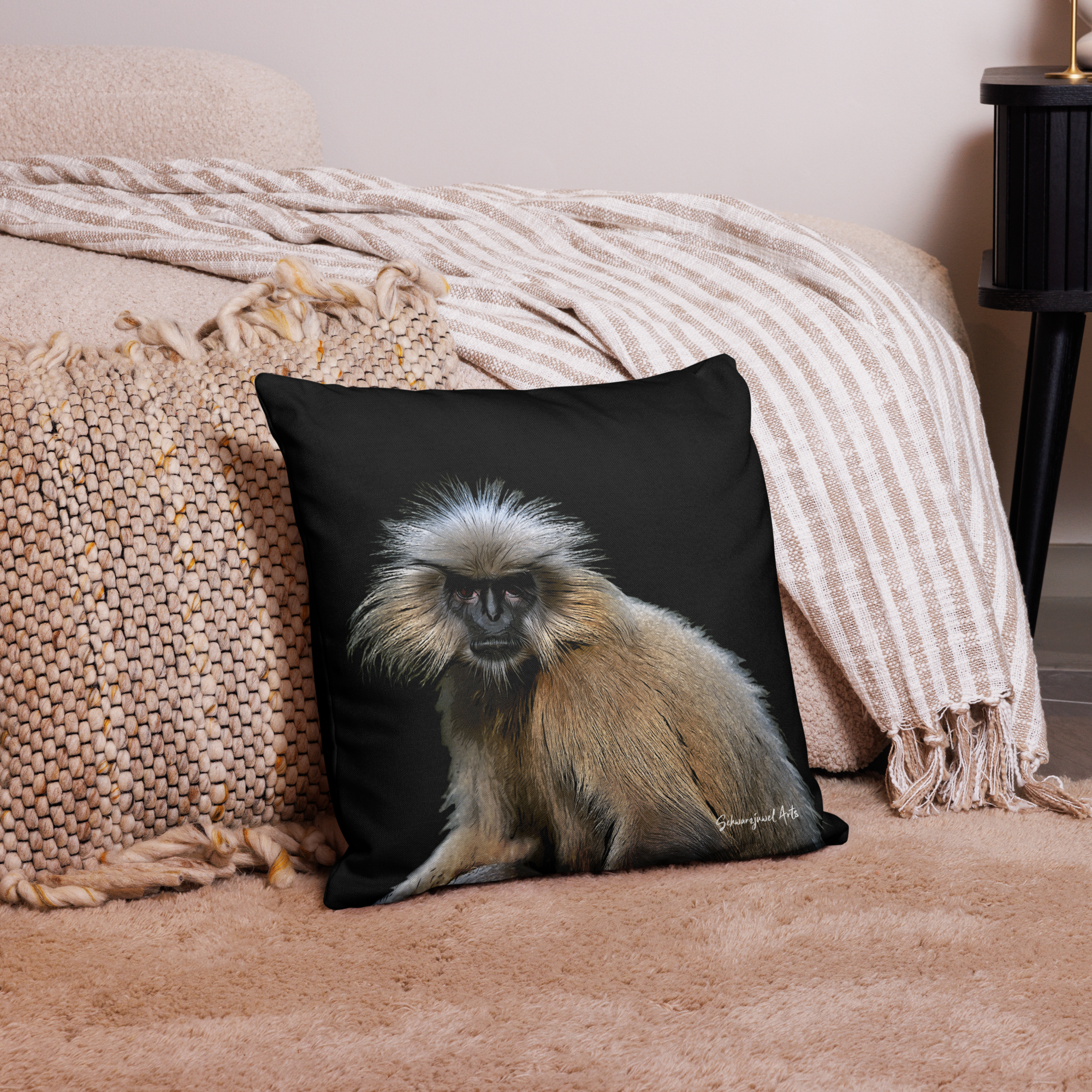 Schwarzes Kissen mit Galdlangur auf heller Couch